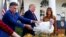 El presidente Donald Trump concede el perdón presidencial a un pavo, mientras el criador Wellie Jackson lo sostiene. [Archivo/noviembre 2019]
