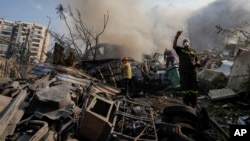 Pekerja pertahanan sipil memadamkan api saat asap mengepul dari lokasi serangan udara Israel di Dahiyeh, Beirut, Lebanon, Jumat, 1 November 2024. (Foto: AP)