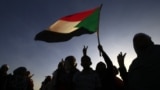 FILE - Demonstrators wave a flag in Khartoum, Sudan, Nov. 25, 2019.