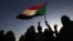 FILE - Demonstrators wave a flag in Khartoum, Sudan, Nov. 25, 2019.