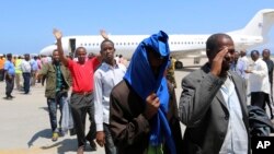 FILE- Deported Somali nationals gesture as they arrive at the airport in Somalia's capital of Mogadishu, April 9, 2014. Sixty-eight Somalis arrived in Magodishu Friday, having been deported by U.S. immigration authorities.