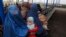 FILE - Afghan refugee women sit with their babies as they wait with others to be repatriated to Afghanistan, at the United Nations High Commissioner for Refugees (UNHCR) office on the outskirts of Peshawar, Feb. 2, 2015.