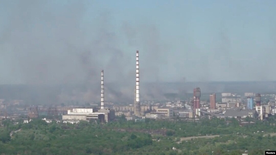 Asap hitam tampak mengepul sementara pasukan Rusia membombardir pabrik kimia di Sievierodonetsk, Ukraina timur hari Minggu (12/6). 
