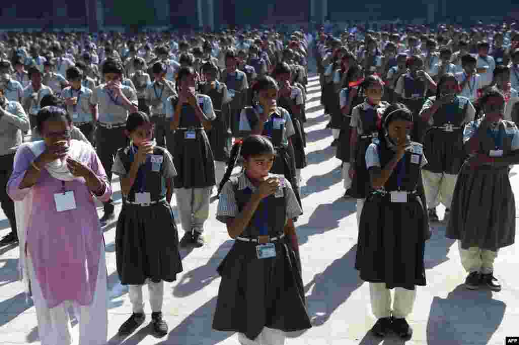 Students drink after participating in a jumping jack event to mark International Day of the Girl Child at Sarkhej Kelavni Mandal in Ahmedabad, India.