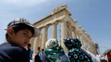 یک کودک افغان که مهاجر است، در مقابل بنای ۲۵۰۰ ساله پارتنون. این بنا نیایشگاه و معبدی در آکروپولیس آتن است.<br />
دولت یونان از میان ۵۰ هزار پناهجوی داخل این کشور ، هر از گاهی برخی را برای تماشای موزه ها می برد.<br />
&nbsp;