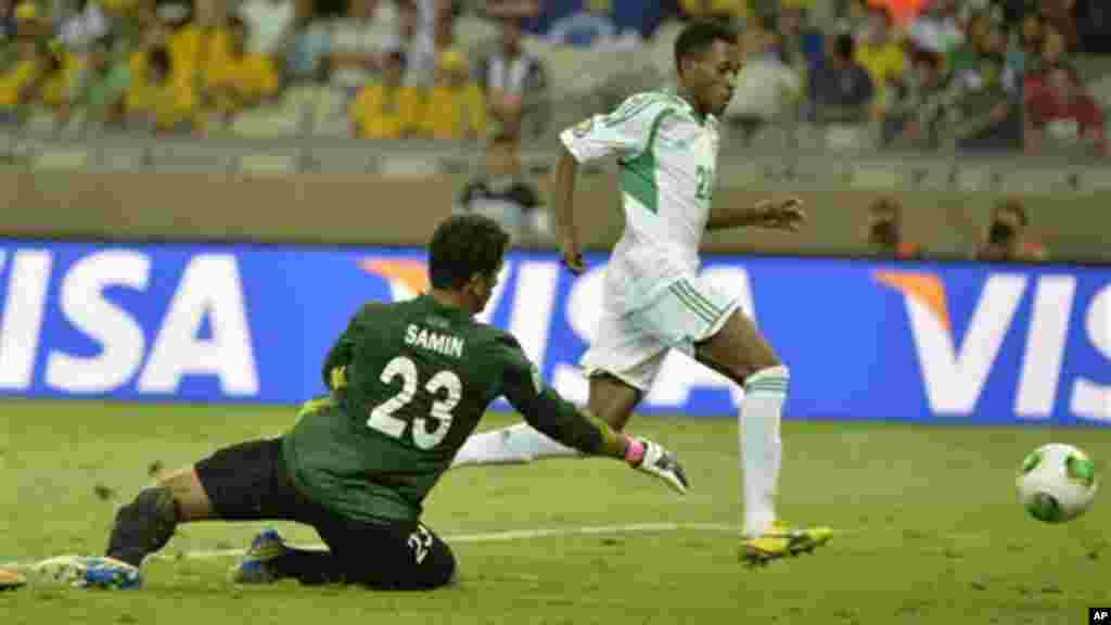 Nigeria's Nnamdi Oduamadi, right, scores his side's 5th goal past Tahiti's Xavier Samin during the Confederations Cup match..