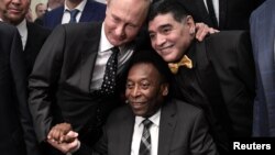 FILE - Russian President Vladimir Putin, left, Brazilian soccer legend Pele, center, and Argentinian soccer legend Diego Armando Maradona attend the 2018 soccer World Cup draw in the Kremlin in Moscow, Dec. 1, 2017.
