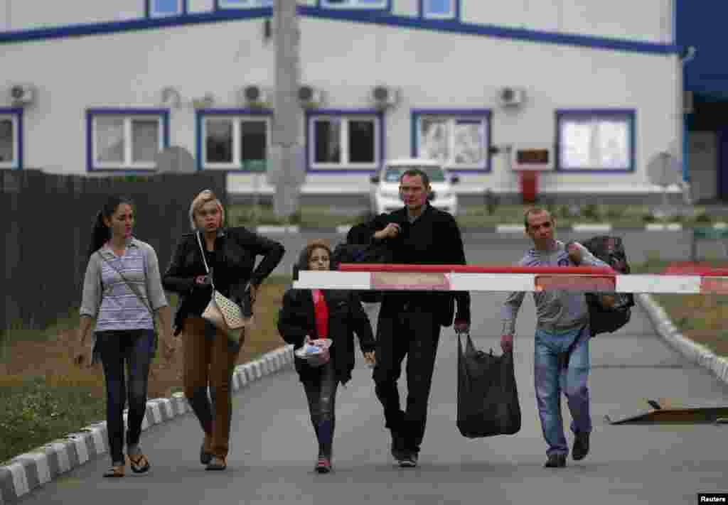 Ukrainian refugees walk from Ukraine into Russia at a border crossing point in Russia's Rostov region, Aug. 19, 2014.