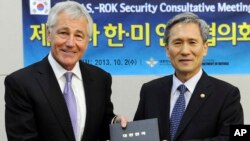 In this photo provided by the South Korean Defense Ministry, U.S. Secretary of Defense Chuck Hagel, left, poses for photos with his South Korean counterpart Kim Kwan-jin, Oct. 2, 2013.
