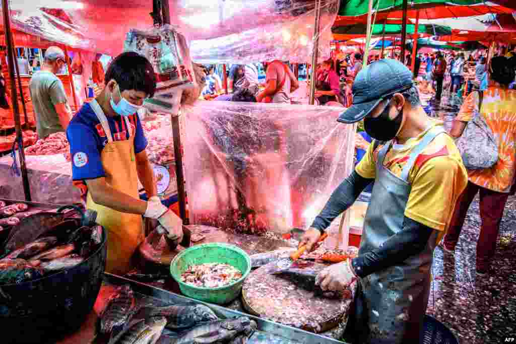 Selelrs clean fish at Khlong Toei Market, the biggest fresh market in Bangkok, Thailand.