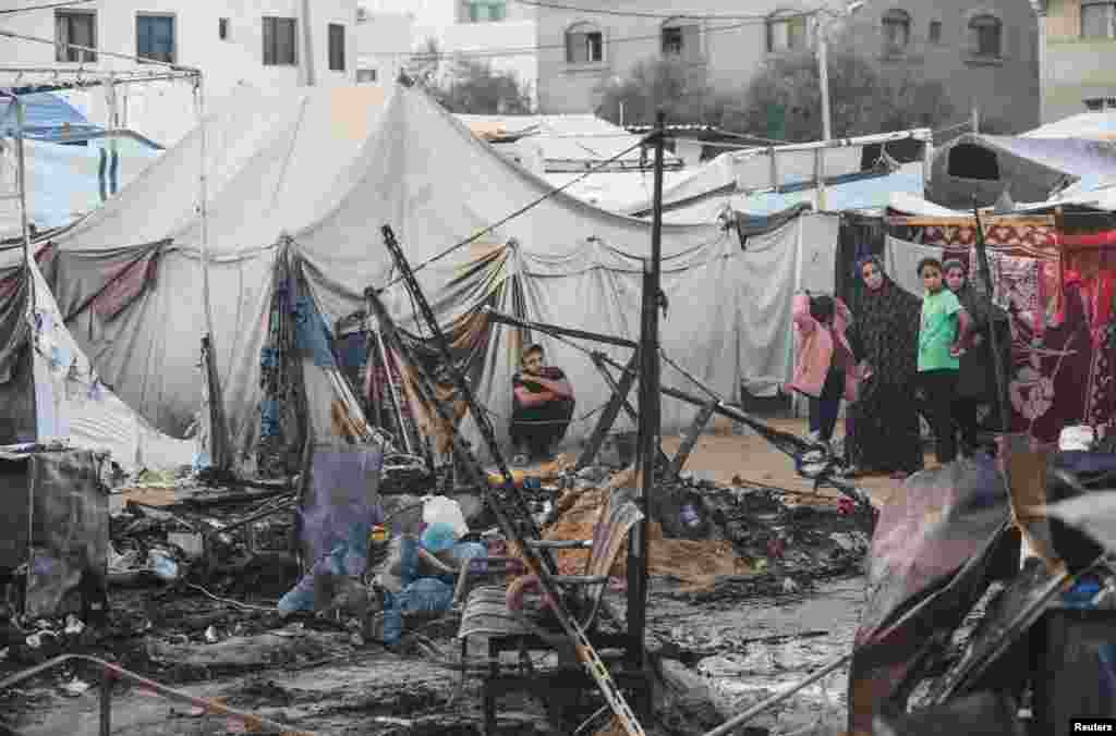 Palestinians survey the damage at the site of an Israeli strike on tents sheltering displaced people at Al-Aqsa Martyrs hospital in Deir Al-Balah in the central Gaza Strip.