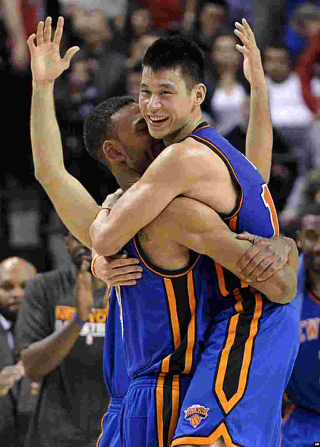 New York Knicks guard Jeremy Lin (R) and Jared Jeffries celebrate their win against the Toronto Raptors during the second half of their NBA basketball game in Toronto, February 14, 2012. (Reuters)