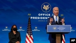 President-elect Joe Biden speaks about the COVID-19 pandemic during an event at The Queen theater, Jan. 14, 2021, in Wilmington, Del., as Vice President-elect Kamala Harris listens. 