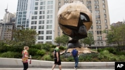 Visitors to the World Trade Center stop to look at the Koenig Sphere in Liberty Park, Sept. 6, 2017, in New York. 