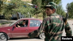 FILE - A serviceman stands guard at a roadblock outside Dushanbe, Sept. 24, 2010. 