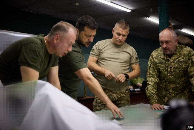 FILE - Ukrainian President Volodymyr Zelenskyy, second from left, and Colonel-General Oleksandr Syrskyi, left, visit the brigades engaged in offensive operations in the Donetsk region on Sept. 5, 2023. (Ukrainian Presidential Press Office via AFP)