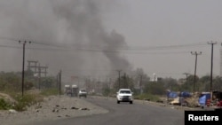 FILE - Smoke rises from a government building in al-Houta, the provincial capital of Yemen's southern Lahej province, March 21, 2015. Officials say the city is now back under government control after troops trained by the Saudi-led coalition routed al-Qaida militants.