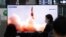 Arhiva - Ljudi gledaju TV program na kome se vidi fotografija severnokorejske nove vodeće rakete, tokom emisije vesti, na železničkoj stanici u Seulu, Južna Koreja, 26. marta 2021.