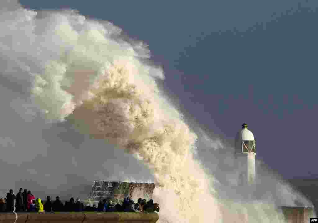 Huge waves strike the harbor wall and lighthouse at Porthcawl, south Wales, as Storm Ophelia hits the UK and Ireland.