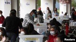 A man casts a ballot during a referendum on a new Chilean constitution in Santiago, Chile, Oct. 25, 2020.