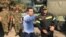 FILE - Greek Prime Minister Alexis Tsipras speaks with a firefighter officer as he visits the village of Mati, following a wildfire near Athens, Greece, July 30, 2018.