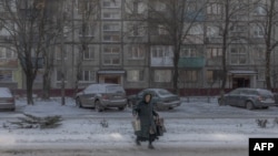 Una mujer mayor camina por un vecindario nevado en Dobropillya, en la región oriental de Donetsk, el 13 de diciembre de 2024, en medio de la invasión rusa a Ucrania. (Foto: Roman Pilipey / AFP).