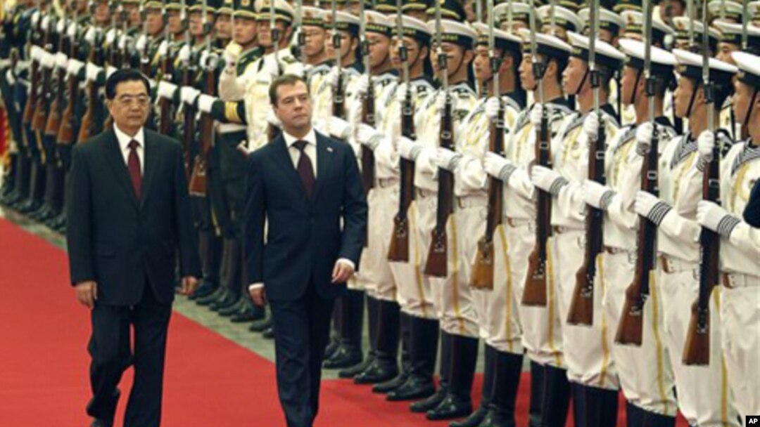 Russian President Dmitry Medvedev, center, with his Chinese counterpart Hu Jintao inspects a guard of honor during a welcoming ceremony at the Great Hall of the People in Beijing Monday, Sept. 27, 2010