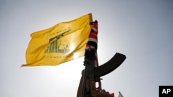 Una partidario de los hutíes levanta una bandera de Hezbollah durante una protesta contra Israel y Estados Unidos en Saná, Yemen, el viernes 27 de septiembre de 2024. 