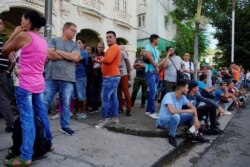 People line up outside a shop selling products for dollars in Havana, Oct. 28, 2019.