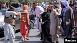 A member of the Taliban points his gun at protesters in Kabul, Afghanistan Sept. 7, 2021.