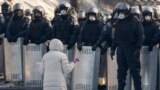 A woman kneels as she appeals to Ukrainian police troops at the site of clashes with anti-government protesters in Kyiv. Protesters erected more street barricades and occupied a government ministry building on Friday after the failure of crisis talks. 