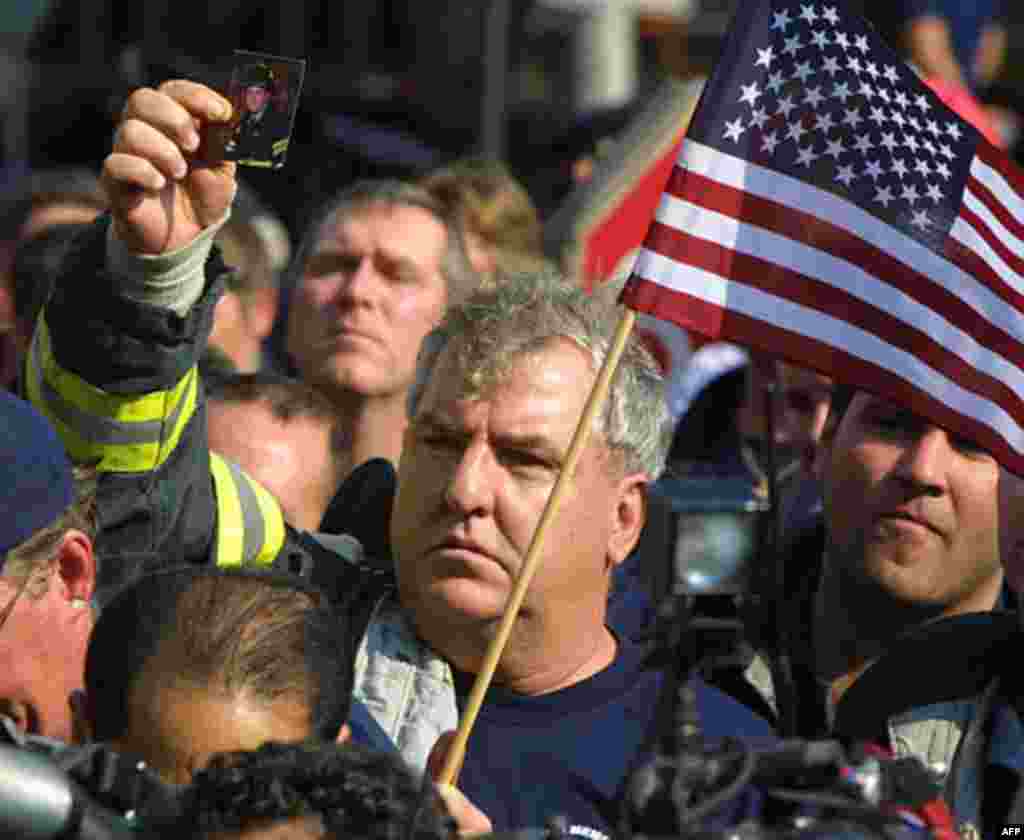 Captain James Henry of Ladder 149, holds a picture of his nephew, firefighter Joseph Henry, missing from the World Trade Center disaster, Friday, Nov. 2, 2001, during a rally in New York. Angry New York City firefighters protested a plan to scale back the