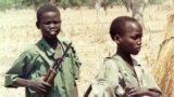 Two Sudanese boy soldiers keep watch outside a rebel military headquarters in remote southern Sudan Feb. 13, 2000. The Sudan People’s Liberation Movement-North (SPLM-N) has agreed to end and prevent the recruitment and use of children in conflict.