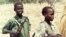 Two Sudanese boy soldiers keep watch outside a rebel military headquarters in remote southern Sudan Feb. 13, 2000. The Sudan People’s Liberation Movement-North (SPLM-N) has agreed to end and prevent the recruitment and use of children in conflict.