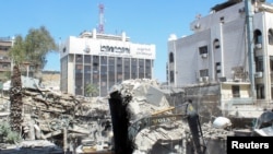 An excavator clears rubble after a suspected Israeli strike on Iran's consulate, in Damascus