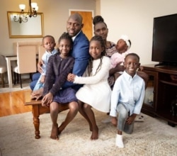 Chol Majok is pictured with his wife and children in a photo from his Facebook campaign page.