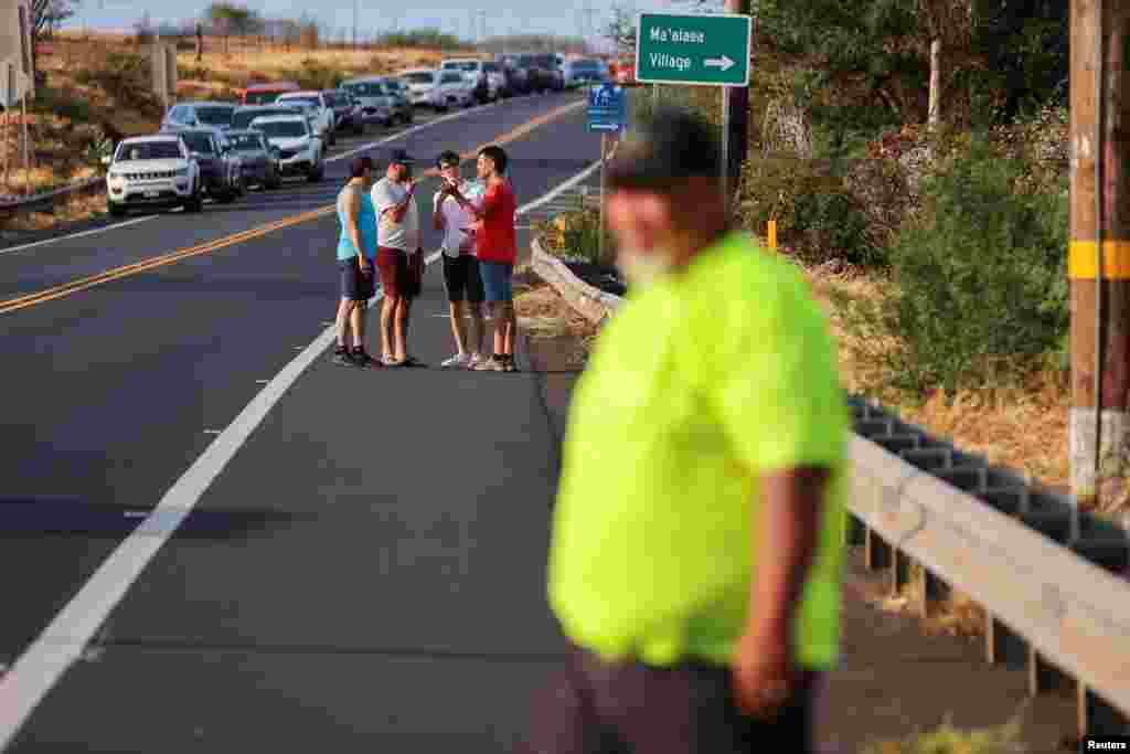 People line up at a police roadblock while trying to get information as they wait to get access to west Maui which has been cut off by wildfires that destroyed much of the historic town of Lahaina, Aug. 9, 2023.&nbsp;