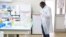 Dr. Mombo dons his white coat as he prepares to analyse samples at the Franceville International Centre of Medical Research (CIRMF) is seen on June 12, 2018 in Franceville.