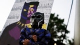 Mason Wilkes, 4, of South Carolina poses in a Black Panther costume, in front of a painting, during a Chadwick Boseman Tribute in Anderson, S.C., Sept. 3, 2020.