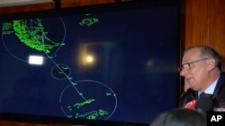 In this image made from video, Gen. Eduardo Mosqueira, right, of the Fourth Air Brigade speaks to the media next to a map of the area where the airplane is missing, in Punta Arenas, Chile, Dec. 9, 2019.