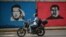Un motociclista pasa junto a un mural que representa al fallecido presidente venezolano Hugo Chávez (1954-2013) y al presidente venezolano Nicolás Maduro (Der) en Caracas el 26 de septiembre de 2024.