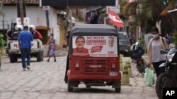 A taxi drives past with a campaign poster on rear window promoting late Mayor Francisco Gaitan, in Cantarranas, Honduras, Nov. 27, 2021.