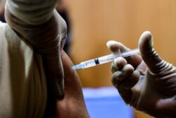 A health worker receives COVID-19 vaccine at a hospital in Kolkata, India, Jan. 16, 2021. India started inoculating health workers Saturday in what is likely the world's largest COVID-19 vaccination campaign.