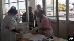 FILE - Nurses from Uganda’s Ministry of Health check passengers arriving from Democratic Republic of Congo, Central Africa at Entebbe Airport Kampala, Uganda, Aug. 8, 2014. 