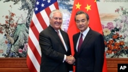 U.S. Secretary of State Rex Tillerson, left, shakes hands with Chinese Foreign Minister Wang Yi before their meeting at the Great Hall of the People in Beijing, Sept. 30, 2017.