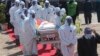 Health officials carry the coffin of Zimbabwean minister Perence Shiri, who died of COVID-19, during his burial in Harare.