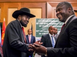 FILE - In this file photo dated June 21, 2018, South Sudan's President Salva Kiir, left, and opposition leader Riek Machar, right, shake hands during peace talks in Addis Ababa, Ethiopia.