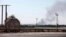 Smoke rises near oil tanks after heavy fighting between rival militias broke out near the airport in Tripoli, July 23, 2014. 