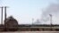 Smoke rises near oil tanks after heavy fighting between rival militias broke out near the airport in Tripoli, July 23, 2014. 