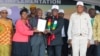 Some of the beneficiaries of the land tenure program receiving 'title deeds" from President Emmerson Mnangagwa